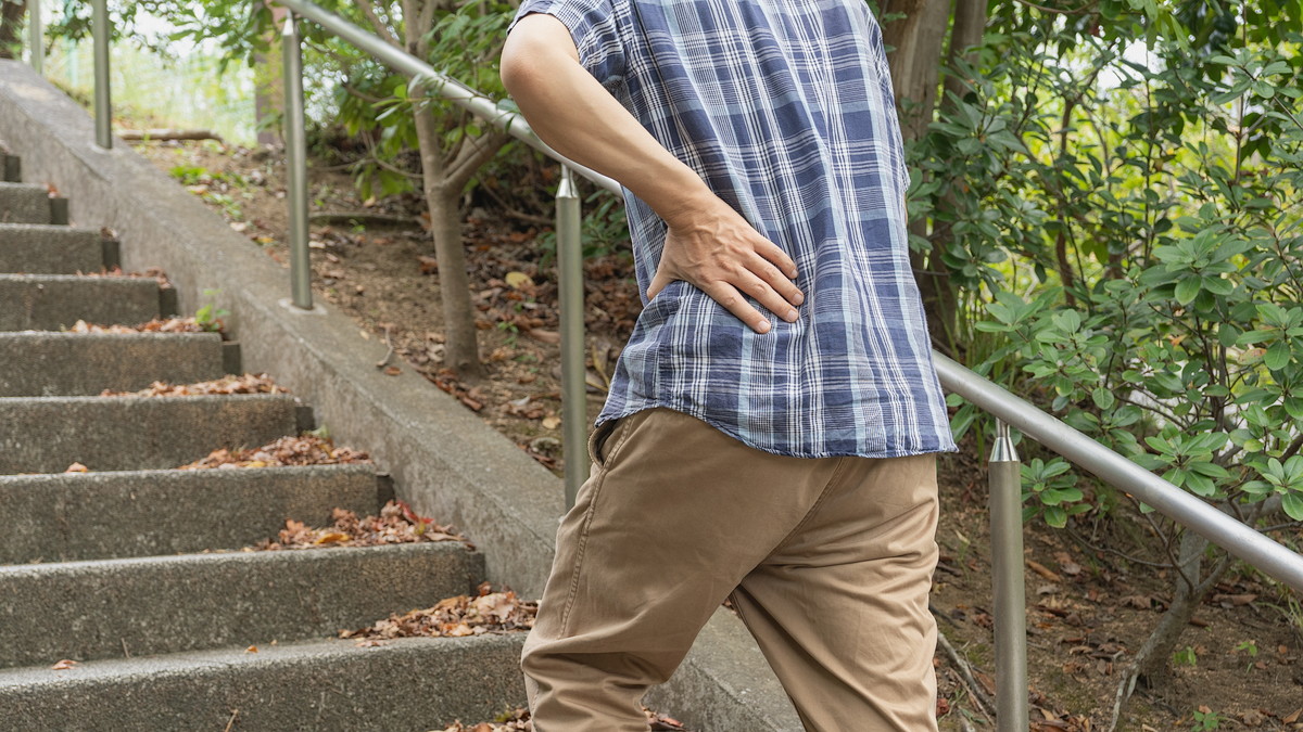 階段を上がってる途中で息が上がってしまう男性