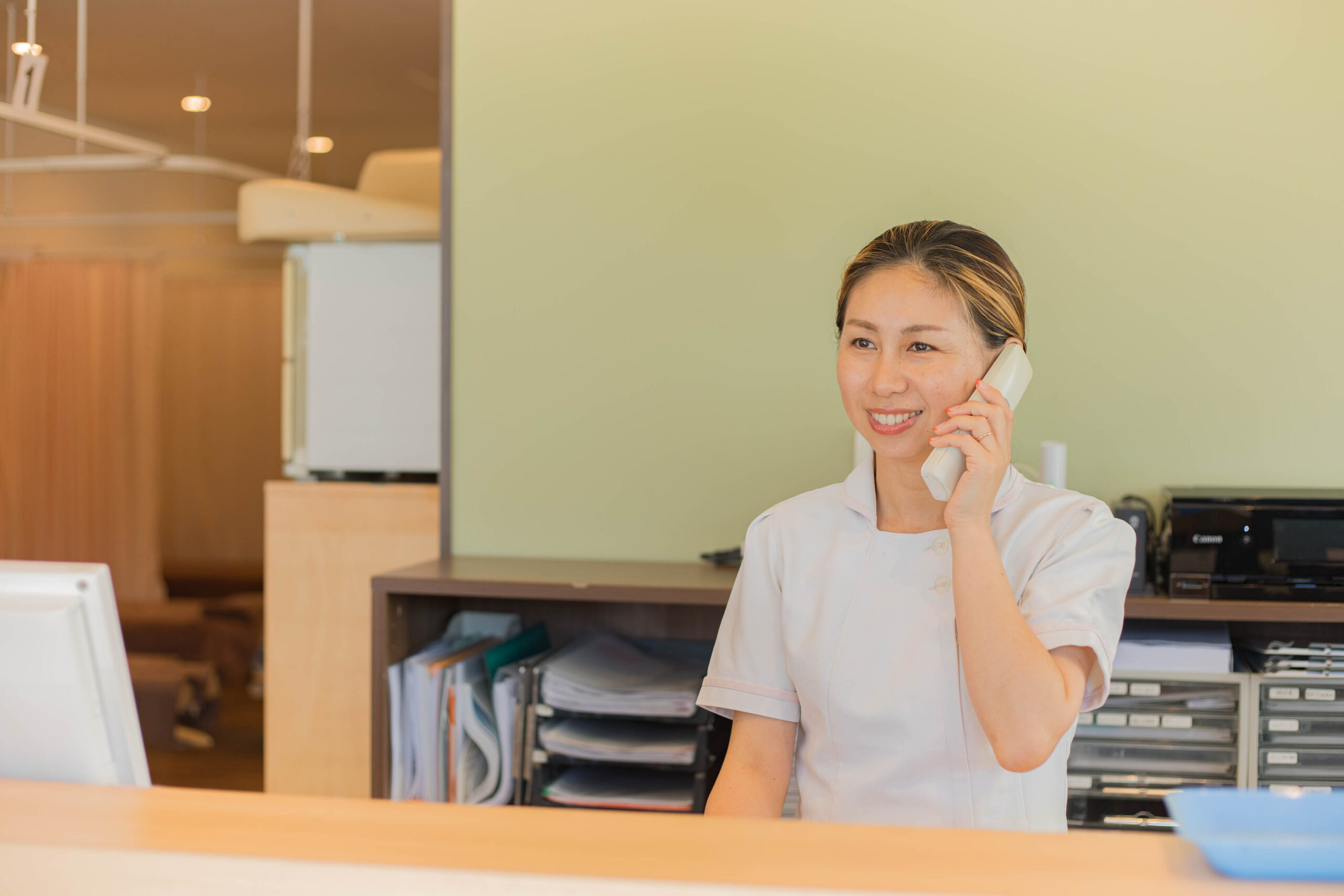 患者様からの問い合わせに答えている受付の人